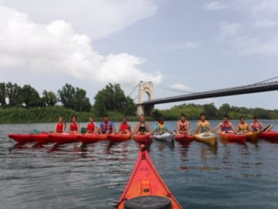 Un grupo animado de kayakistas posa orgulloso frente al histórico puente colgante sobre el río Ebro.