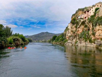 Un grupo disfruta de una travesía en kayak por el río Ebro, pasando por el impresionante paisaje de Miravet, Tarragona.